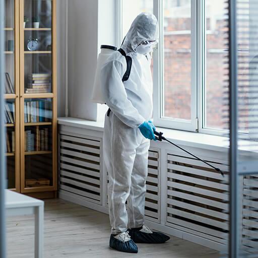 Pracownik wykonujący dezynfekcję po opróżnieniu mieszkania